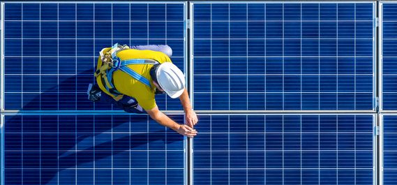 Man working on top of photovoltaic panels